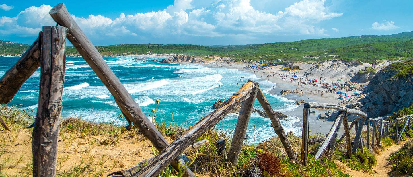 Medinė tvora ant kalvos su vaizdu į Sardinijos paplūdimį ir žydrą jūrą