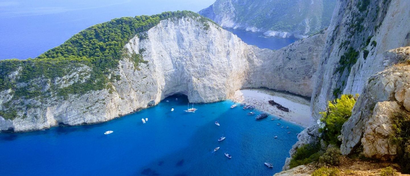 Navagio paplūdimys Zakinte su baltomis uolomis, turkio spalvos vandeniu ir sudužusiu laivu